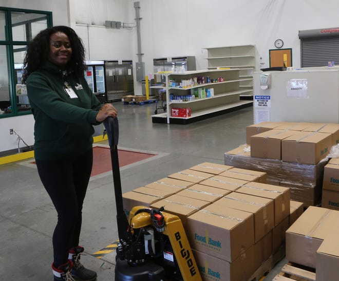 Denise Hurtado-Valdez, a home delivery coordinator with the Food Bank of Delaware, prepares to move a pallet of food for local drivers from Amazon Flex and DoorDash on Jan. 10, 2022.