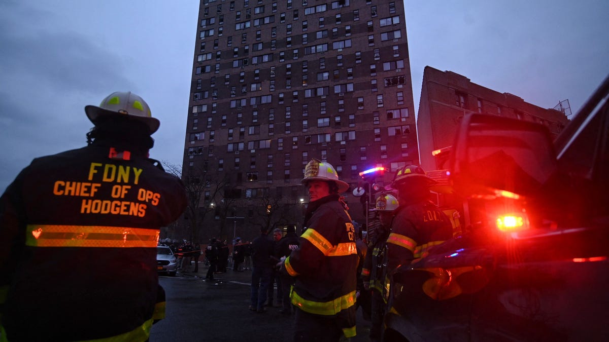 Firefighters work outside an apartment building after a deadly fire in the Bronx, on January 9, 2022, in New York.