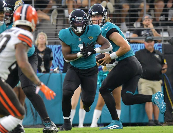 Jacksonville Jaguars running back Travis Etienne (1) fakes taking a handoff from Jacksonville Jaguars quarterback Trevor Lawrence (16) during first quarter action. The Jacksonville Jaguars hosted the Cleveland Browns for their only home preseason game at TIAA Bank Field in Jacksonville, Florida Saturday night, August 14, 2021. The Browns led at the half 13 to 0.  [Bob Self/Florida Times-Union]