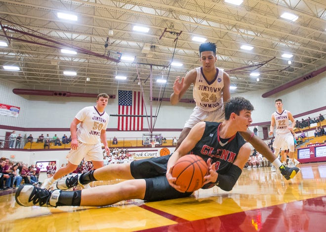 Glenn’s Brycen Hannah (14) tries to keep the ball in play and away from Jimtown’s Preston Phillips (24) during the John Glenn vs. Jimtown boys sectional basketball game Tuesday, March. 3, 2020 at Jimtown High School in Elkhart.
