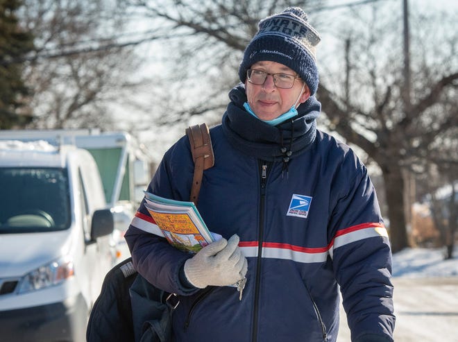 Mail carrier Keith Amidon is dressed for cold weather as he walks his route on Uncatena Avenue Tuesday.