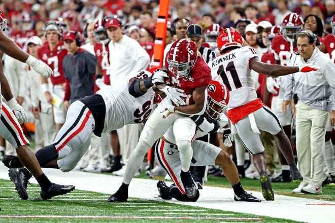 Alabama running back Trey Sanders (6) runs the ball against Georgia linebacker Nolan Smith (4) during the first quarter in the College Football Playoff national championship game at Lucas Oil Stadium.
