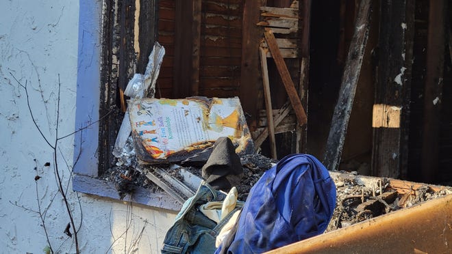 A children's book is charred with now brittle pages on the fire-ravaged window of a gutted bedroom at a West 21st Street home after a fire left a  Jacksonville grandmother dead and her two grandchildren in critical condition.