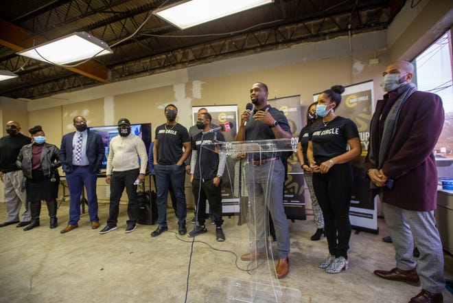 Michael Odupitan, founder and CEO of Topeka's Omni Circle Group, surrounds himself with Omni Circle members Wednesday after announcing that Kansas City, Mo.'s Ewing Marion Kauffman Foundation has awarded it $360,000 in grant funding, which it will use to encourage entrepreneurship by racial minorities.