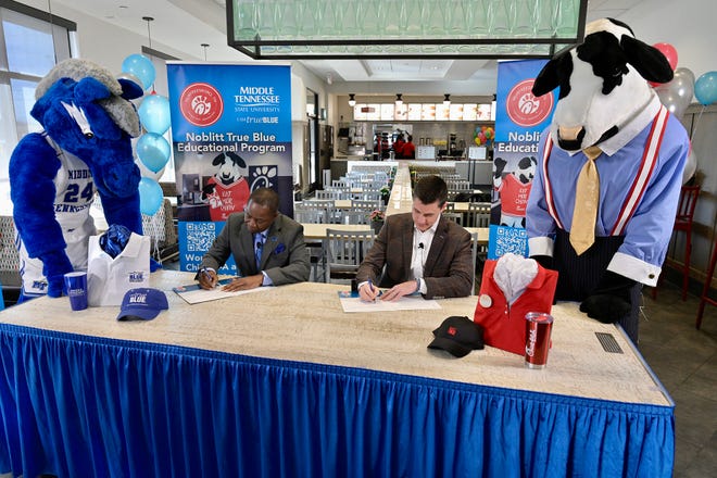 With their respective mascots looking on, MTSU President Sidney A. McPhee, seated left, and Beau Noblitt, restaurant operator for Chick-fil-A Murfreesboro, sign an agreement Wednesday, Jan. 12, at the fast-food chain’s Memorial Boulevard location that provides tuition assistance for qualifying local employees.