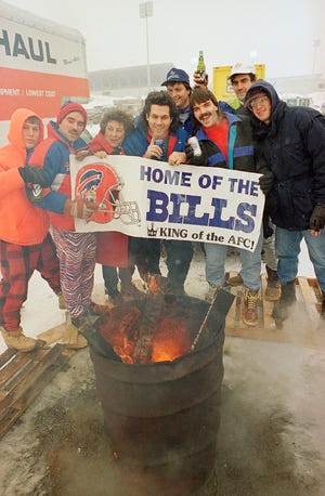 Buffalo Bills fans cheer on their team while staying warm in temperatures hovering around zero in the Parking lot Rich Stadium Several hours before the Bills Play the Los Angeles Raiders in their AFC divisional play off game in Orchard Park, N.Y., Saturday, Jan. 15, 1994.