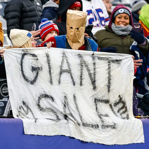 A New York Giants fan holds a banner while wearing