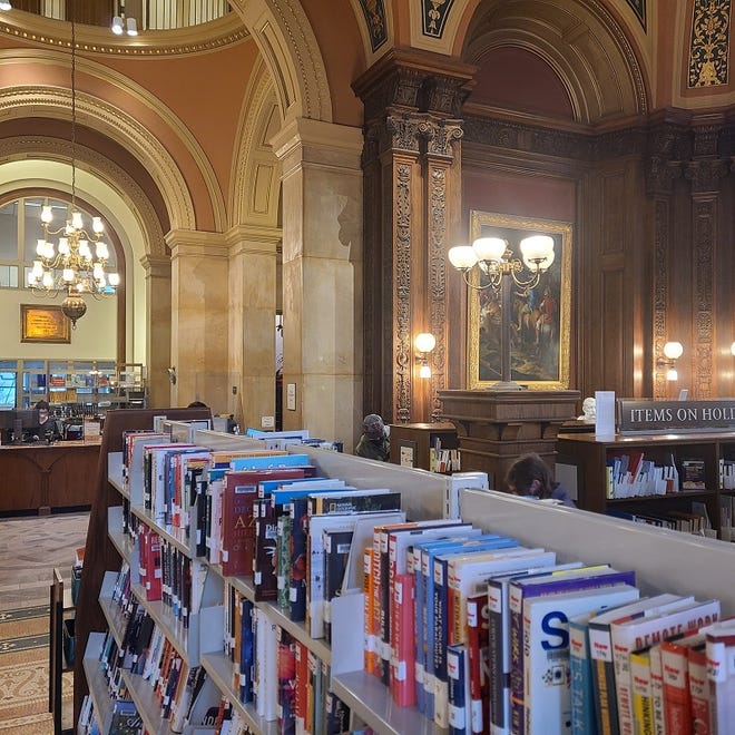 A view from the Robbins Library Reading Room to the main circulation desk.