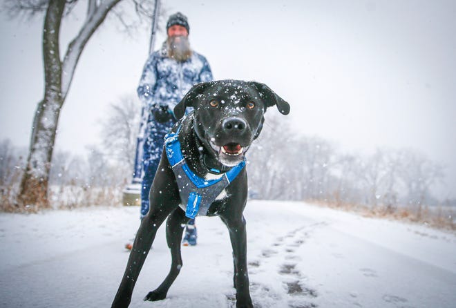 Nate Fisher of Des Moines, Iowa, walks his 1-year-old dog, Alaska, in Des Moines during a winter storm on Jan. 14.