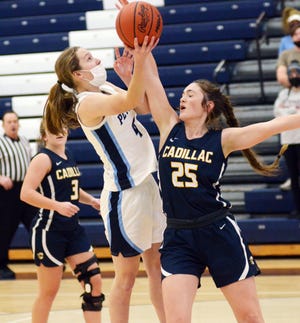 Petoskey's Kenzie Bromley (left) makes a move on and goes up for a shot over Cadillac's Anna Whipple during the second half of Friday's game.