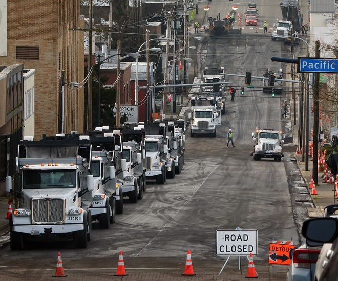 Trucks line Sixth Street in downtown Bremerton as they pave the street on Friday.