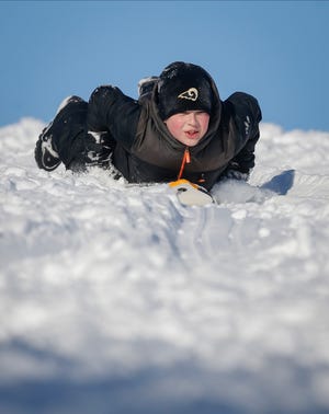Owen Tewes, 11, of Altoona slides down a hill at Grandview Park in Des Moines on Saturday, Jan. 15, 2022.
