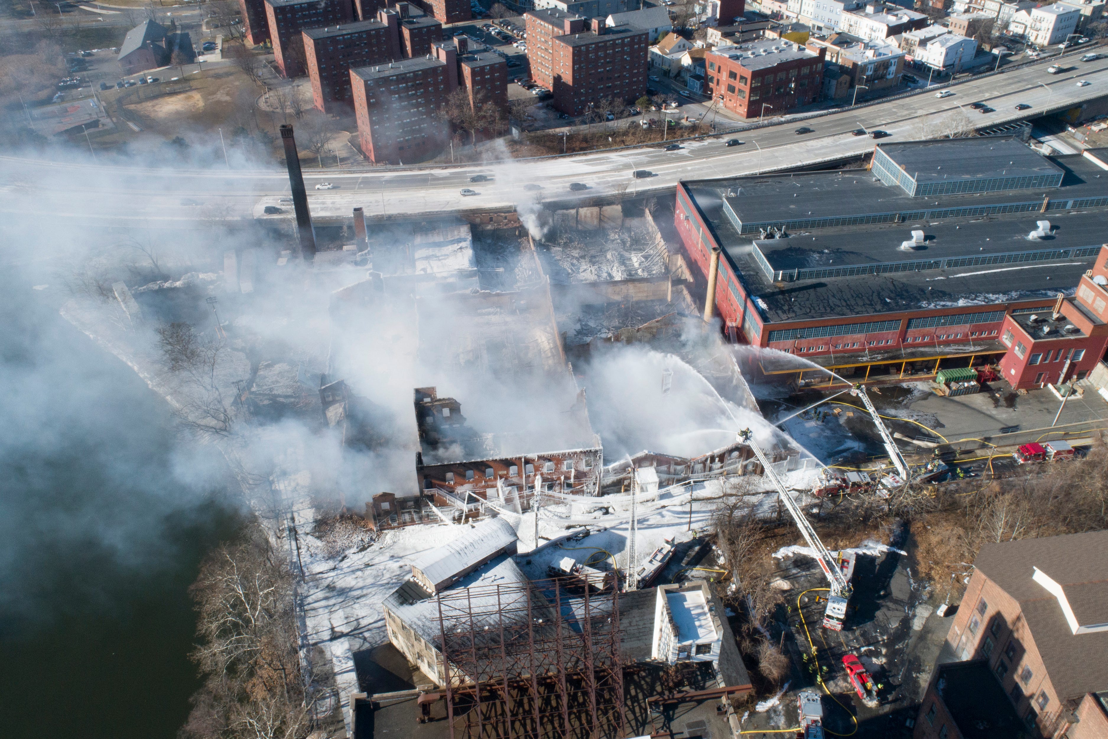 The January 2022 fire that destroyed old industrial buildings at the Majestic Industries-Qualco site in Passaic occurred just a few hundred feet from the red brick towers of the Alfred Speer Village public housing complex, seen at the top of this photo.