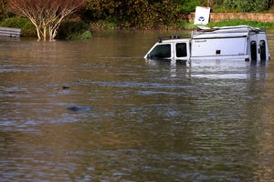 A pickup is partially submerged in Santa Cruz early Saturday as the surge from a tsunami created by an underwater volcano near Tonga inundated a parking lot at the Upper Harbor. Moments later all the water receded from the lot before flooding it again shortly thereafter.