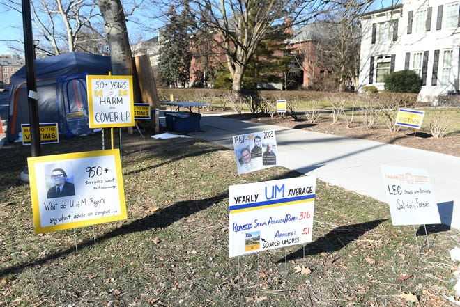 Signs seen at the University of Michigan near the president's residence in Ann Arbor on Sunday, Jan. 16, 2022.
