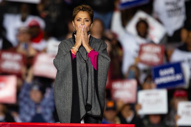 Kari Lake holds her hands to her mouth while leaving the stage ahead of former President Donald Trump's speech in Florence on Saturday, Jan. 15, 2022.