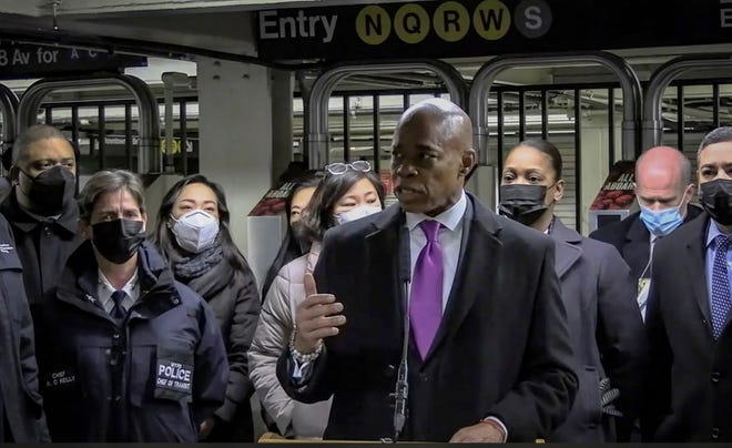 In this livestream frame grab from video provided by NYPD News, Mayor Eric Adams, foreground, with city law officials, speaks at a news conference inside a subway station after a woman was pushed to her death in front of a train at the Times Square station on Jan. 15, 2022.