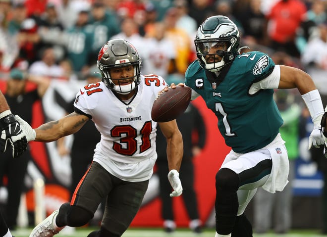Philadelphia Eagles quarterback Jalen Hurts runs with the ball as Tampa Bay Buccaneers safety Antoine Winfield Jr. defends.