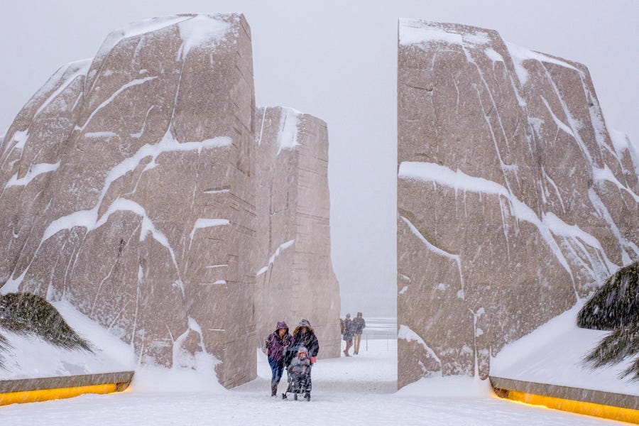 Visitors walk through the Martin Luther King, Jr. Memorial as a winter storm blows through the Washington area.