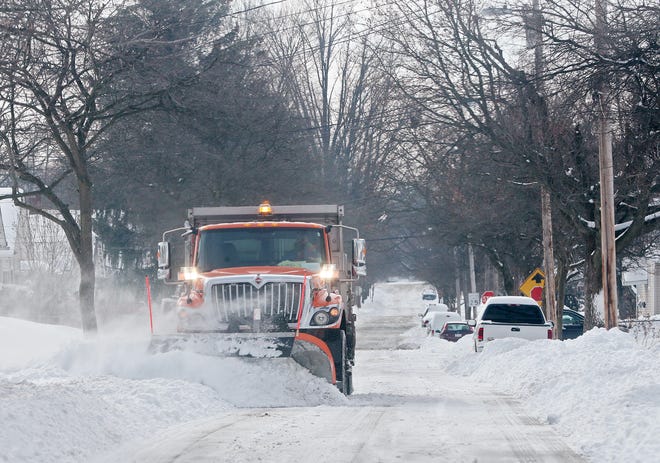 An Akron city snowplow clears Allendale Avenue near Archwood Avenue on Tuesday in East Akron.