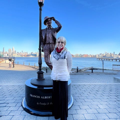 Carolyn Palmer stands next to the statue of Frank 