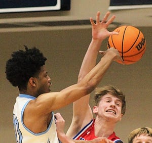 Bartlesville High guard David Castillo, left, makes a pass to the low post to teammate Kent Girard for a crucial fourth-quarter layup during a two-point victory last season.
