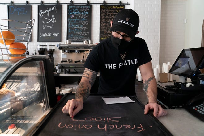 The Statler Market barista Steve Tindall, 32, of Detroit, marks the lunch board Wednesday, Jan. 19, 2022. The Statler Market in Detroit is located on the first floor of the City Club apartments and next to the Statler Bistro. The market offers a coffee bar, grab-and-go items, soups, and grocery items with a European flair such as Andiamo sauce in a jar and Italian pasta.