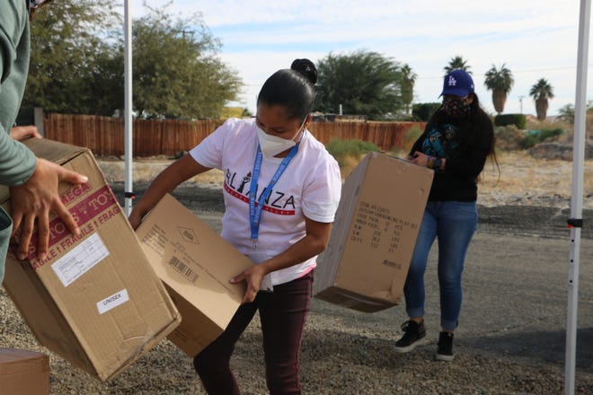 Alianza Coachella Valley volunteers unload boxes for a toy drive in North Shore.