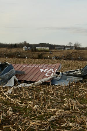 Half of a sign that reads, "Greetings from Walton Creek" lies in a field near Centertown, Ky., after a tornado passed through in early December. The other half of the sign was found a mile away. The message adorned a garage owned by Ben Ashby, whose insurance will only partially cover $128,000 in damage to several buildings on his property.
