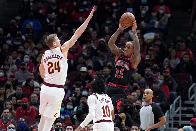 Chicago Bulls' DeMar DeRozan (11) passes under pressure from Cleveland Cavaliers' Lauri Markkanen (24) as Darius Garland (10) also defends during the first half of an NBA basketball game Wednesday, Jan. 19, 2022, in Chicago. (AP Photo/Charles Rex Arbogast)