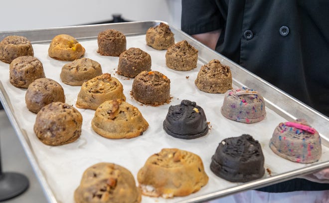 Wade Kinard, empleado de Fat and Weird Cookie Co., muestra una bandeja de galletas en la panadería el jueves.  En el próximo Cookie Fest, la compañía espera romper un récord mundial Guinness para la mayoría de las personas que mojan las galletas.
