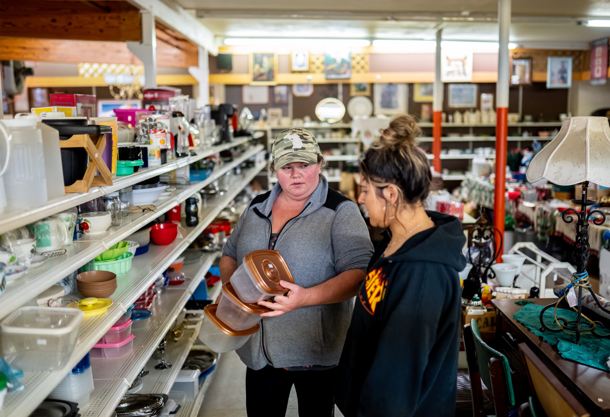Shannon's Home Cooking owner Shannon Greathouse, left, checks in with an employee at the Dis n' Dat flea market she owns in Gwinn on Wednesday, Oct. 20, 2021.