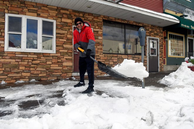 Steve Vernalis shovels snow from the sidewalk in front of his restaurant Vernalis Restaurant on Main South Street in Shenandoah, Pa., on Tuesday, January 18, 2022.