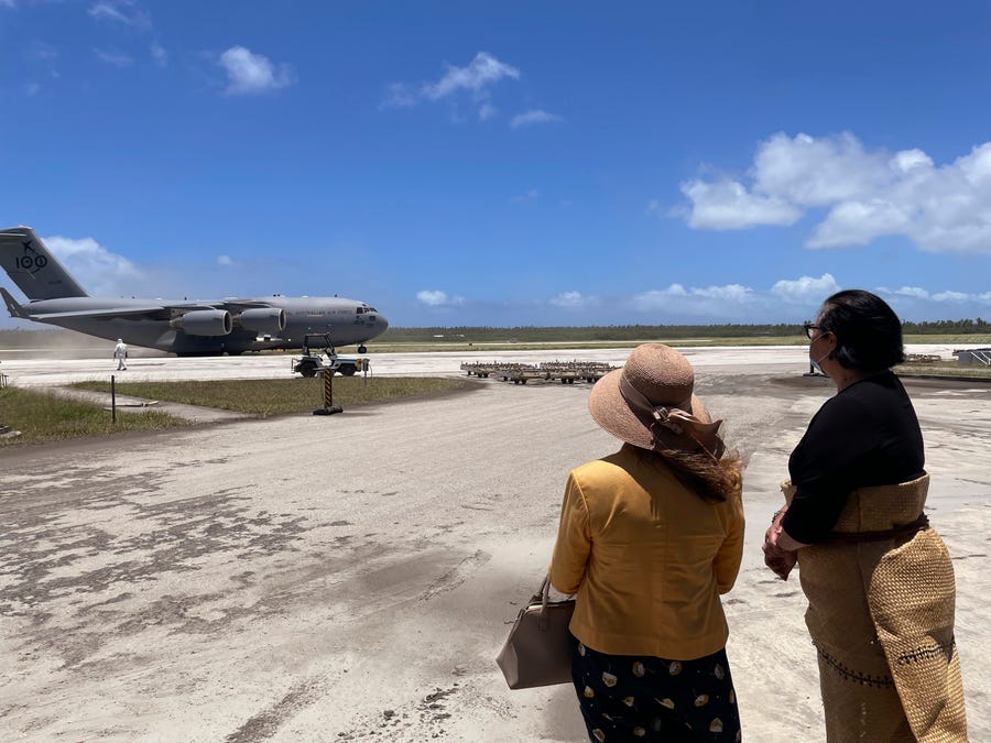 In this photo provided by the Australian Defence Force, the Tongan Foreign Minister, Fekitamoeloa 'Utoikamanu, right, and the Australian High Commissioner to Tonga, Rachael Moore, watch the arrival of the first Royal Australian Air Force aircraft at Fua'amotu International Airport, Tonga, Thursday, Jan. 20, 2022.
