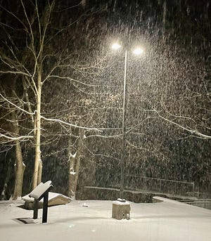 Snow blankets White Mills, the storm picking up in intensity as shown here beneath a lonely street lamp.