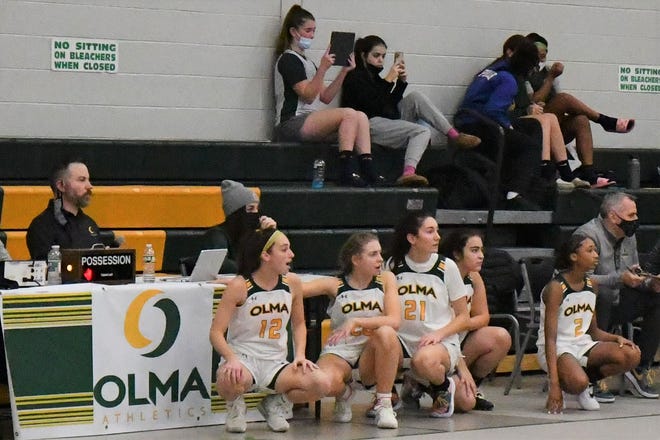 Five Our Lady of Mercy players wait at the scorer's table to enter the game against Egg Harbor