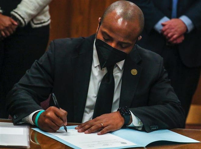 Acting Milwaukee Mayor Cavalier Johnson signs a resolution making elected officials subject to the city's anti-harassment and workplace violence policy Friday.