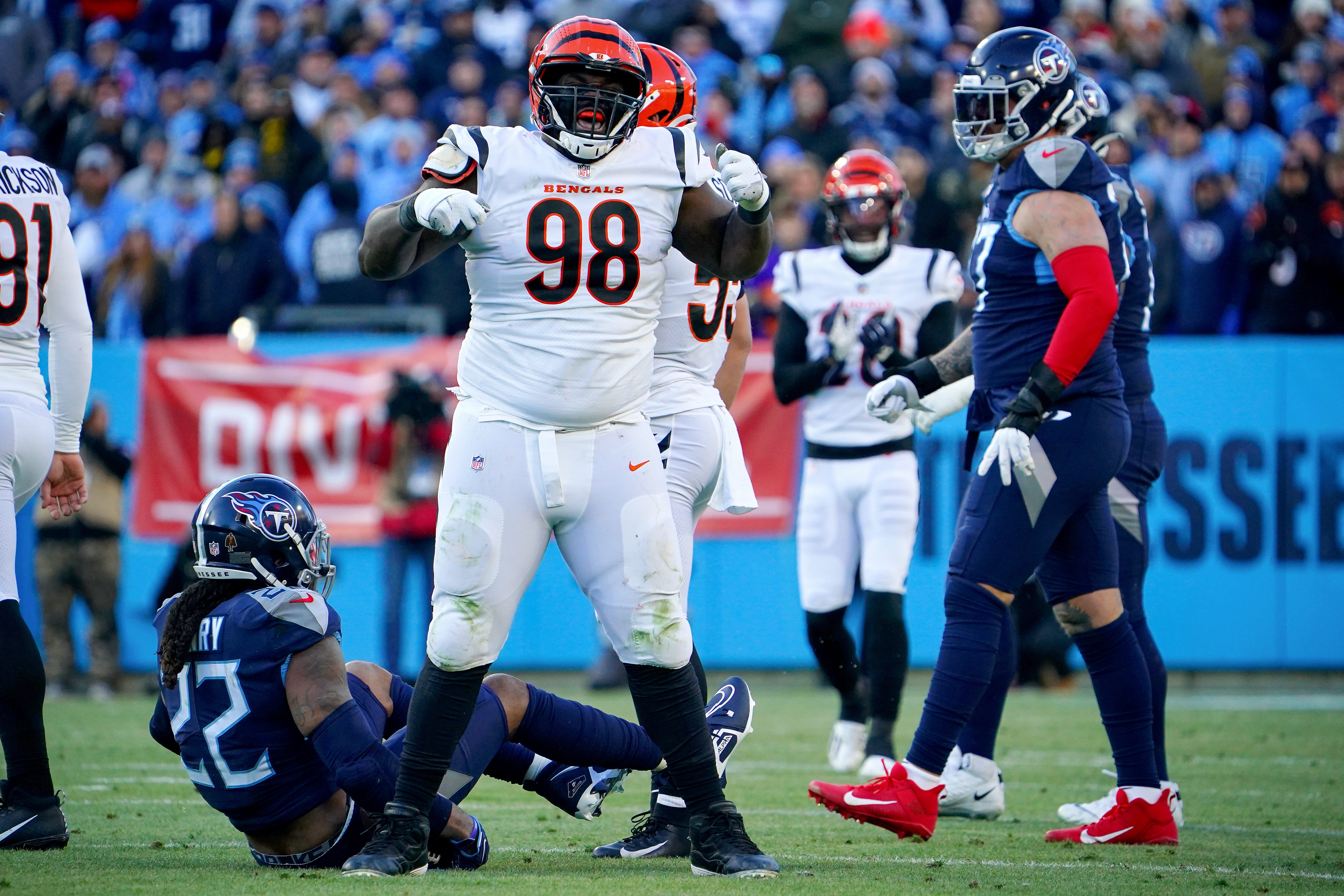 Cincinnati Bengals nose tackle D.J. Reader (98) celebrates a tackle of Tennessee Titans running back Derrick Henry (22), background, in the first quarter during an NFL divisional playoff football game, Saturday, Jan. 22, 2022, at Nissan Stadium in Nashville.