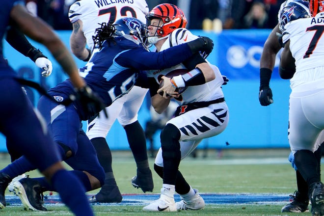 Cincinnati Bengals quarterback Joe Burrow (9) is sacked by Tennessee Titans linebacker John Simon (59) in the first quarter during an NFL divisional playoff football game, Saturday, Jan. 22, 2022, at Nissan Stadium in Nashville.