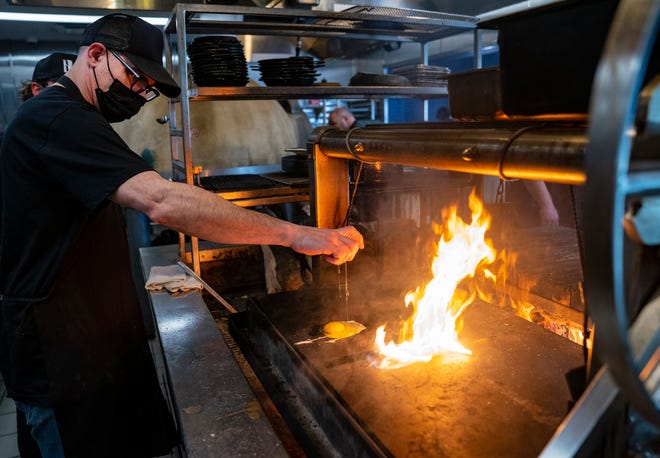 Barda chef Javier Bardauil fries up an egg on the wood-fired grill Jan. 21, 2022.