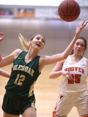 Kiley Dyrlund, 12, of GlenOak reaches for a rebound as Lauren Rose, 25, of Hoover looks on during their game at Hoover on Saturday, Jan. 22.