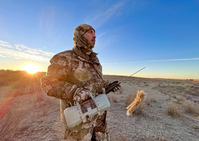 Coyote caller Bryan Garrison, who also runs the contest in Kismet, holds his electronic calling machine and a motorized decoy.