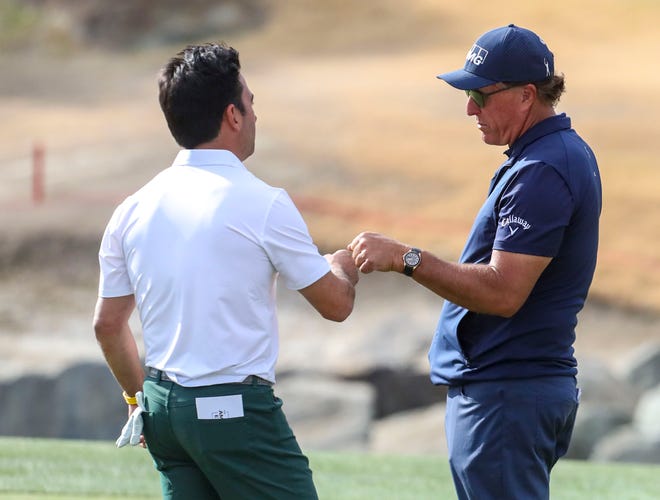Phil Mickelson fist bumps amateur golfer Frank Marzano after a putt on the 11th green of the Pete Dye Stadium course during the third round of The American Express at PGA West in La Quinta, Calif., Saturday, Jan. 22, 2022. 