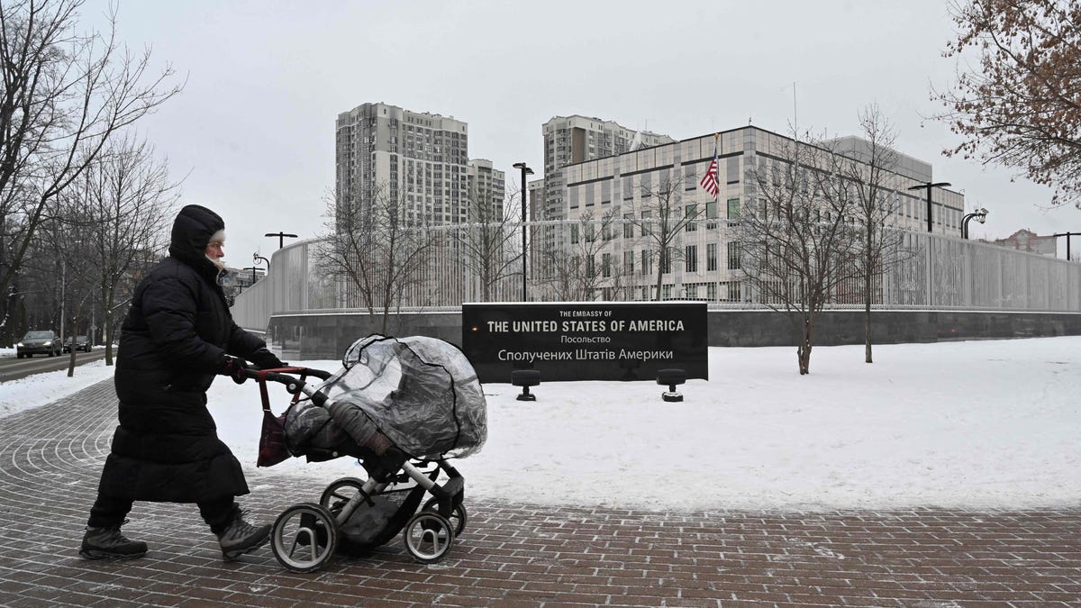 January 24, 2022:   A woman pushes a stroller past the US Embassy in Kyiv.  Ukraine said it was "premature" of the United States to evacuate the families of its diplomatic staff in Kyiv due to fears of a looming Russian invasion.