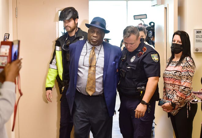 Ben Frazier, founder of the Jacksonville Northside Coalition, is led out of the governor's news conference in handcuffs by members of the Jacksonville Sheriff's Office after refusing to leave the room Jan. 4.