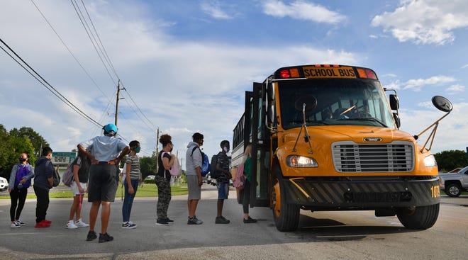 Students line up to board a school bus in Manatee County. The district's transportation department is slated to purchase three to five electric school buses for the 2022-2023 school year, replacing some of the fleet's diesel buses.