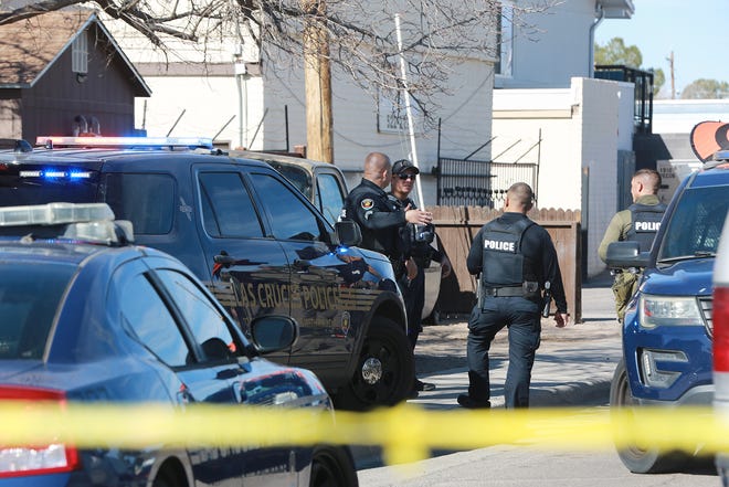 Police officers stand outside an apartment complex on Pecos Street and Foster Road during a SWAT standoff on Jan. 25, 2022.