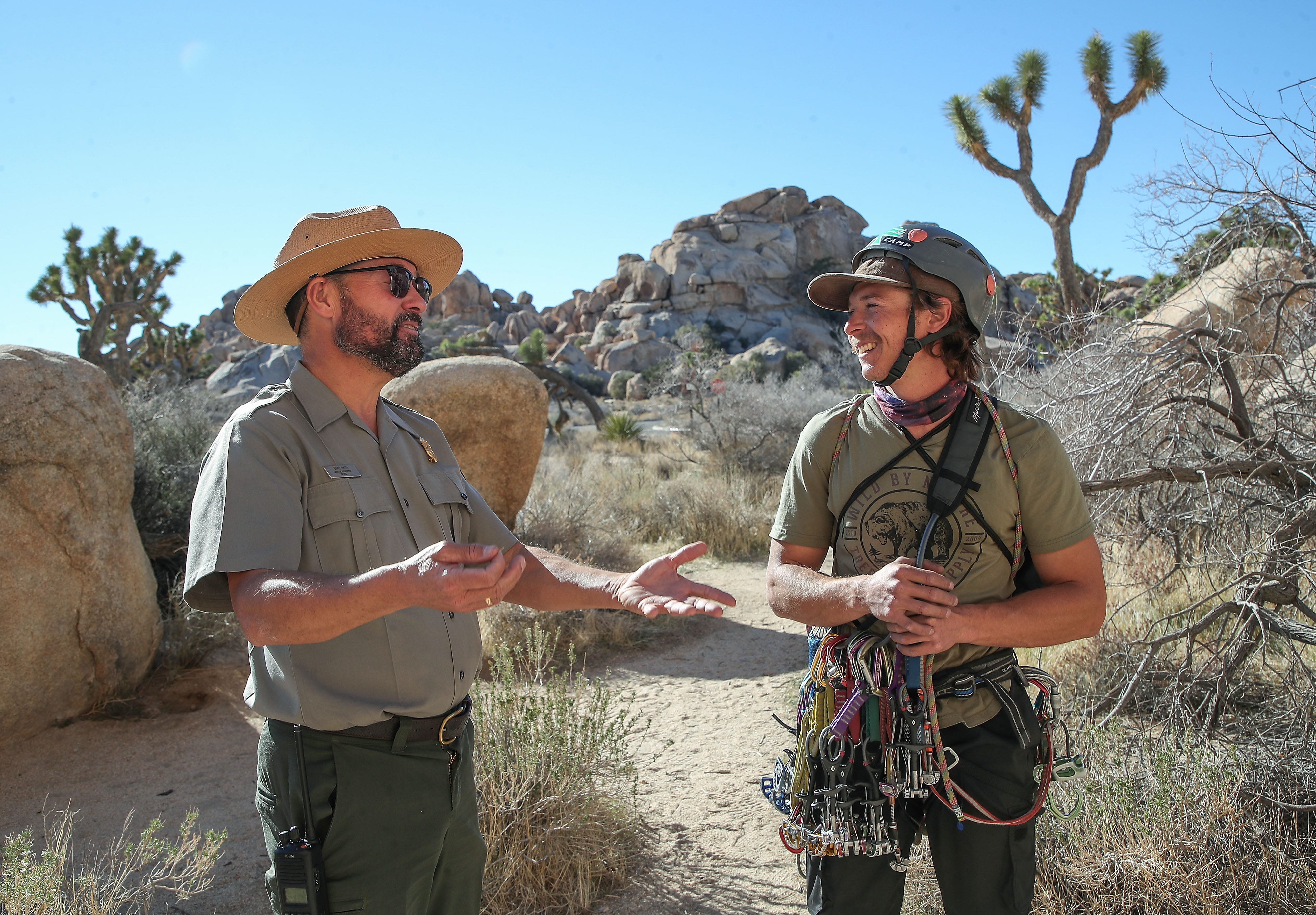 Joshua Tree National Park Superintendent David Smith, left, talks Jan. 24, 2022, with climbing guide Jessy Ware about the future of the iconic site, where the stark beauty and logistical challenges at one of America’s busiest national parks are on equal display.