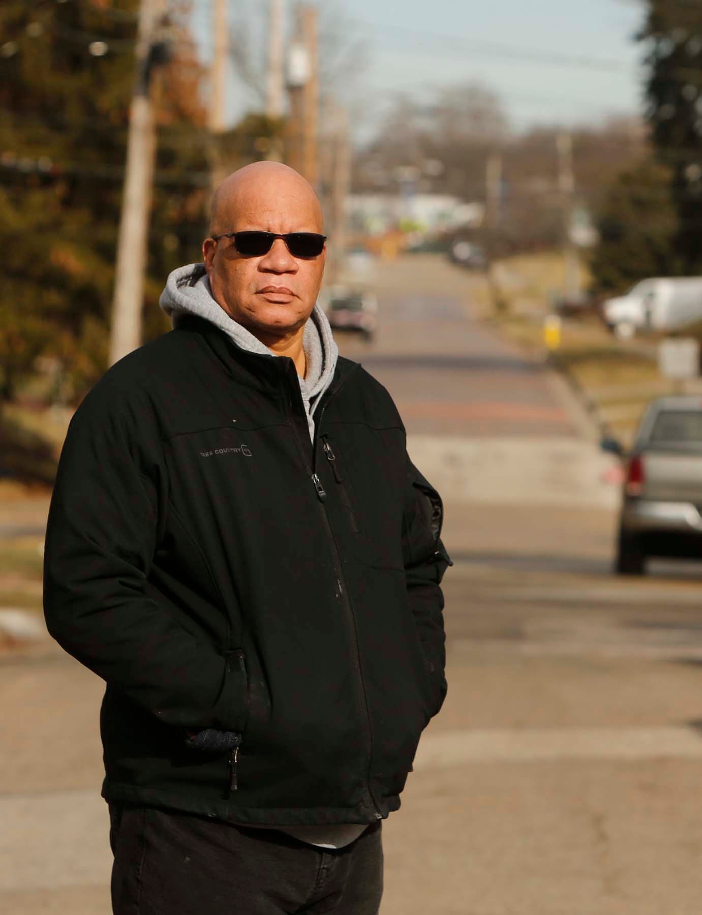 The Rev. Greg Harrison stands on Douglas Street where he grew up and attended an elementary school at the end of the street with his neighbors and friends. The home his family rented was torn down to make way for the Innerbelt. [Karen Schiely, Akron Beacon Journal]