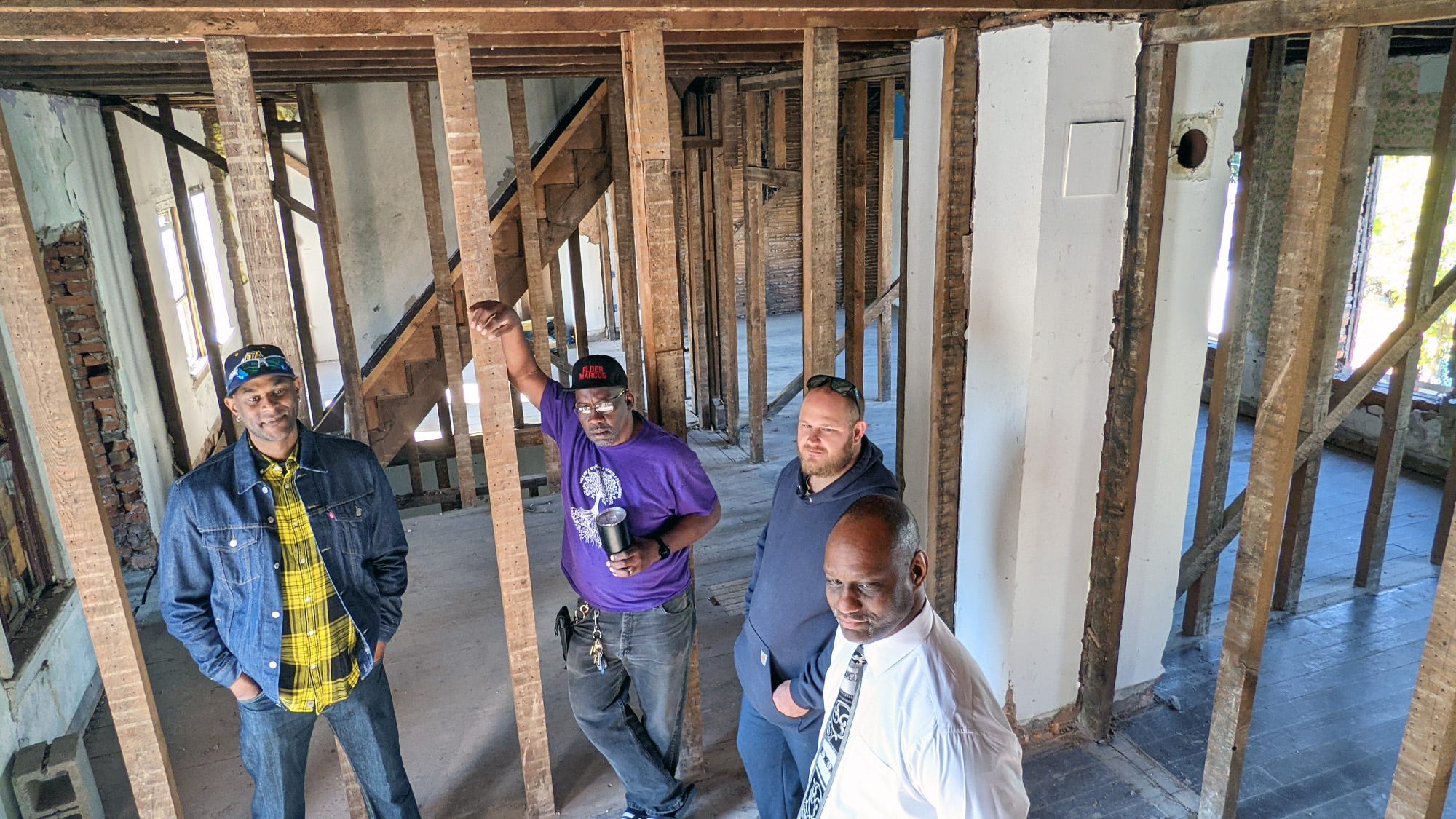 Fred Walker, right, and Anthony Moore, left, gather with people who will be involved in the project on the second floor of one of the properties in their Salem Square redevelopment project on Nov. 11, 2021.